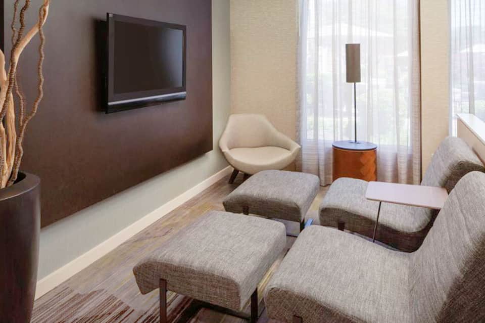 Modern spa relaxation room with comfortable recliners and wall-mounted television
