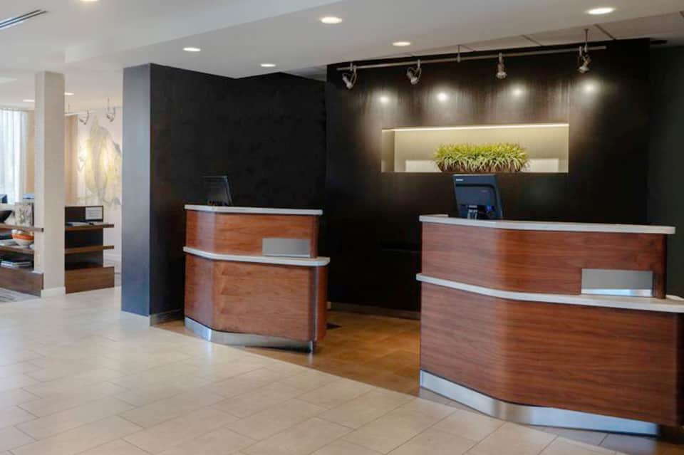 Modern hotel reception desk with wood paneling and ambient lighting