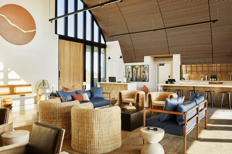 Modern resort lobby with wicker seating, wooden beams, and contemporary design