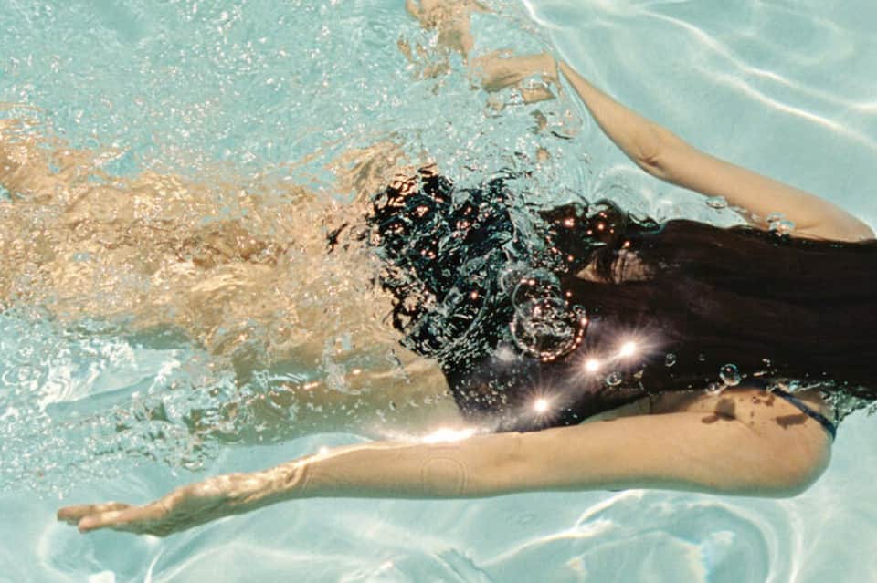 Underwater view of swimmer doing freestyle stroke with water splashing around them