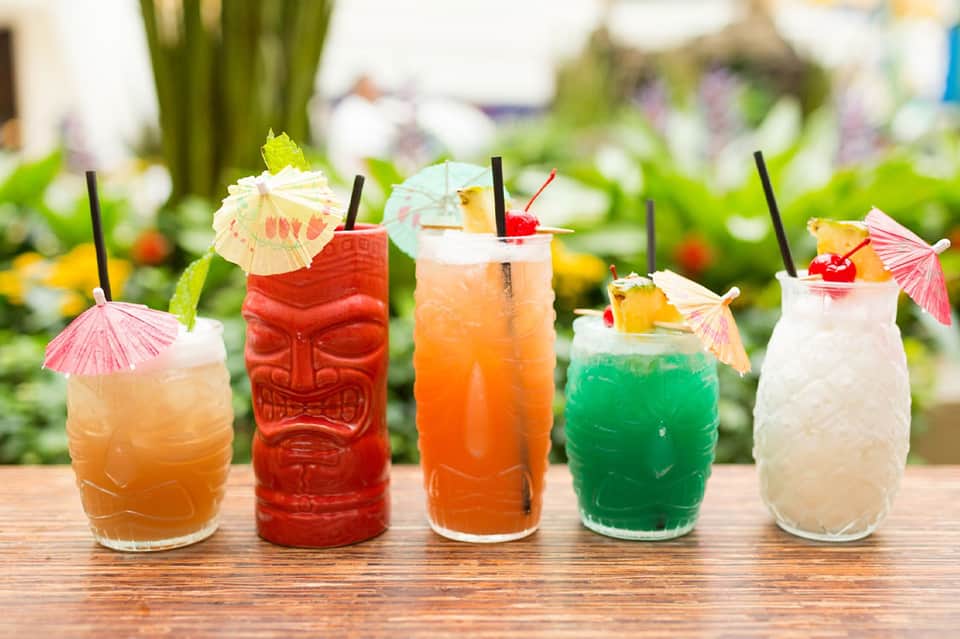 Colorful tropical cocktails with decorative umbrellas and fruit garnishes outdoors