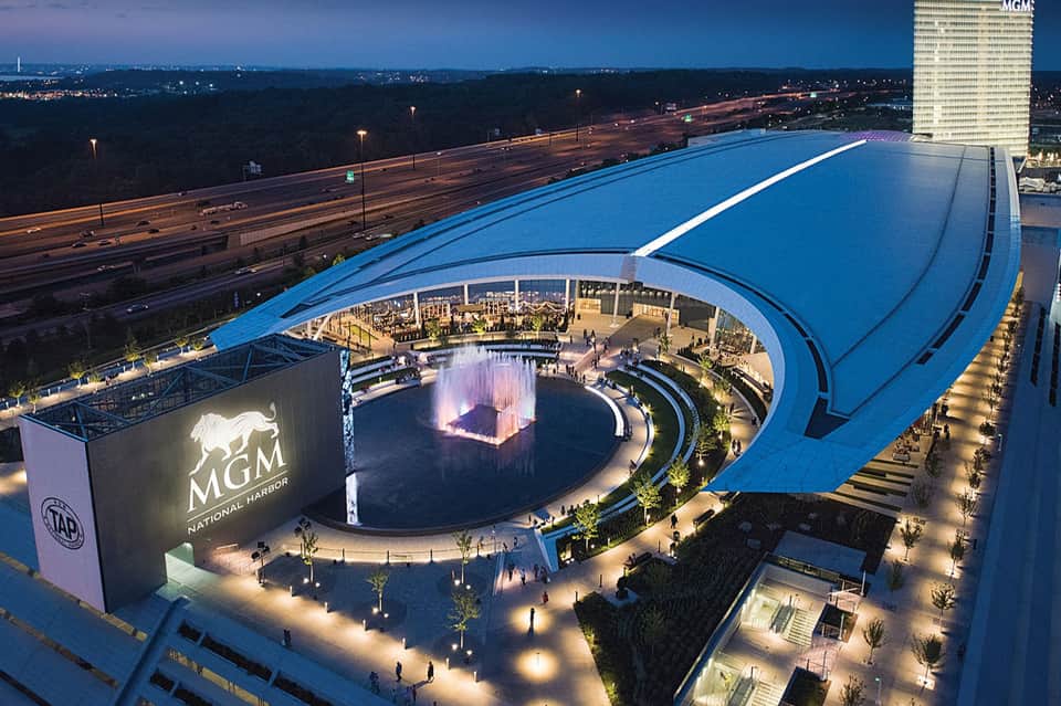 Aerial view of MGM National Harbor entertainment venue with illuminated circular fountain and blue architectural roof structure