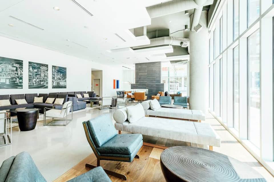 Modern hotel lobby with white marble flooring, contemporary furniture, and floor-to-ceiling windows
