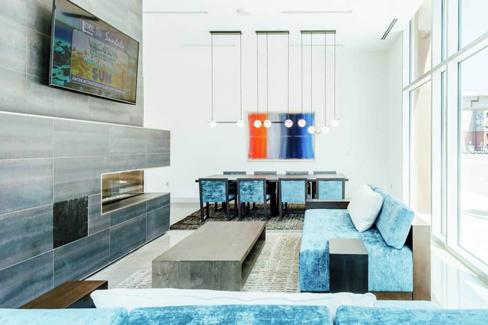 Modern resort lounge with fireplace, blue seating, and oceanview windows
