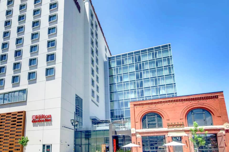 Modern hotel building exterior with Hilton sign, brick building, and contemporary architecture on clear day