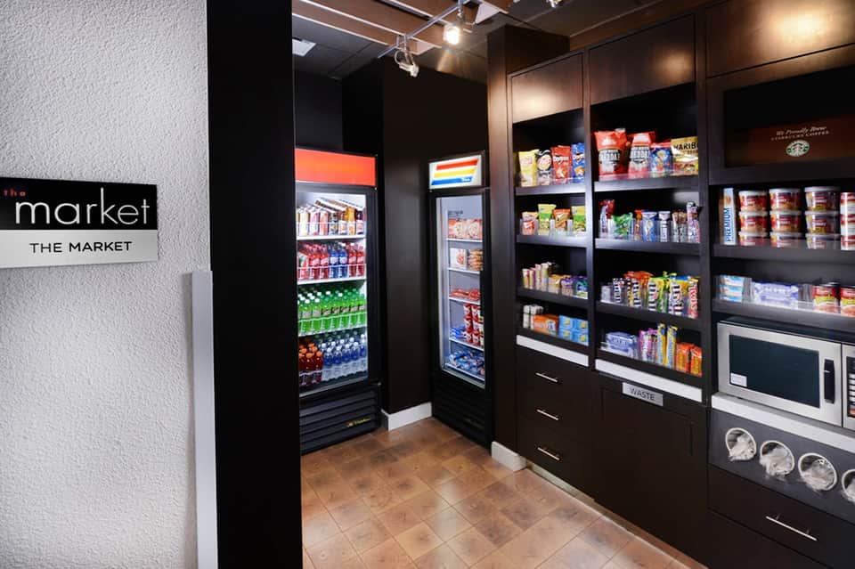 Hotel market convenience store with refrigerated beverage coolers and stocked shelving