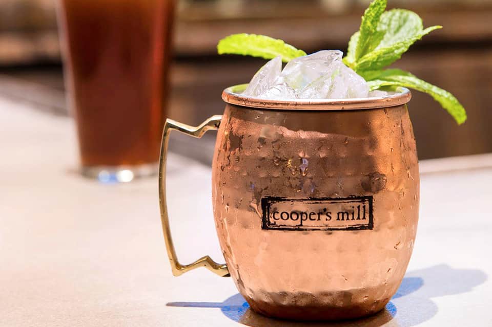 Moscow mule in copper mug with mint garnish at outdoor bar