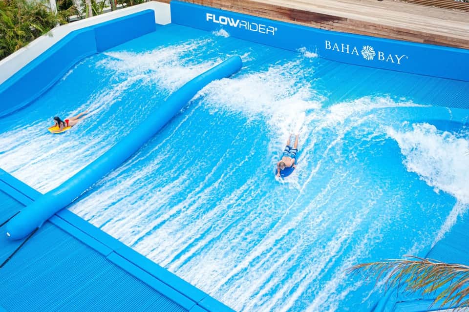 FlowRider artificial wave surf machine at Baha Bay water park with surfers riding waves
