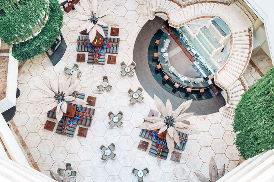 Aerial view of courtyard with circular seating area, colorful striped lounges, and hexagonal pavers