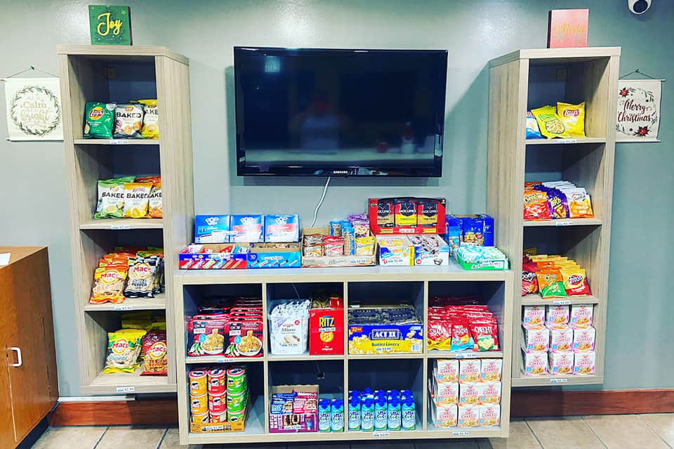 Entertainment center display with TV mounted above snack shelves and wooden storage units