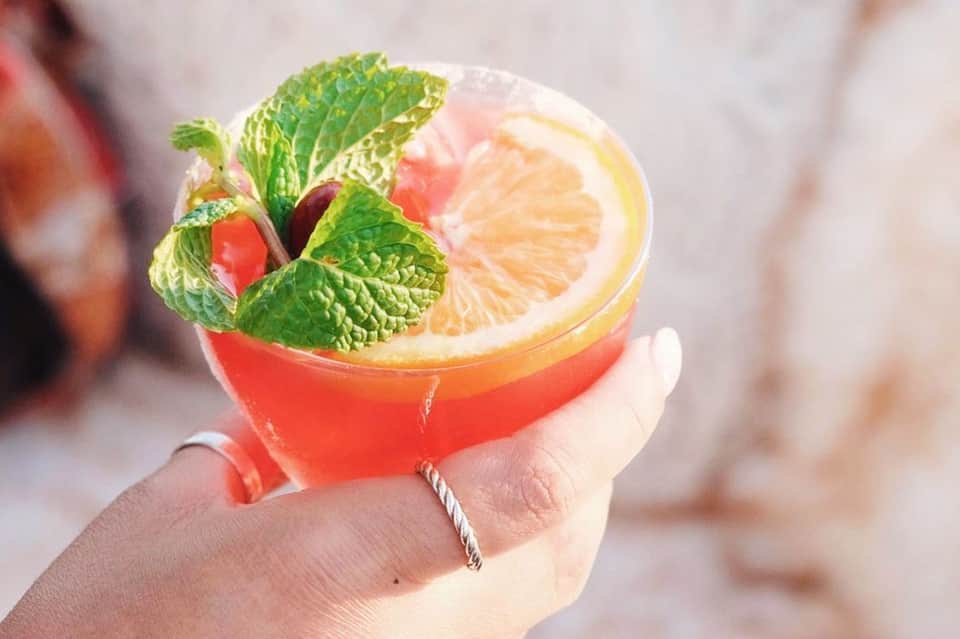 Colorful tropical cocktail with grapefruit slice and fresh mint garnish