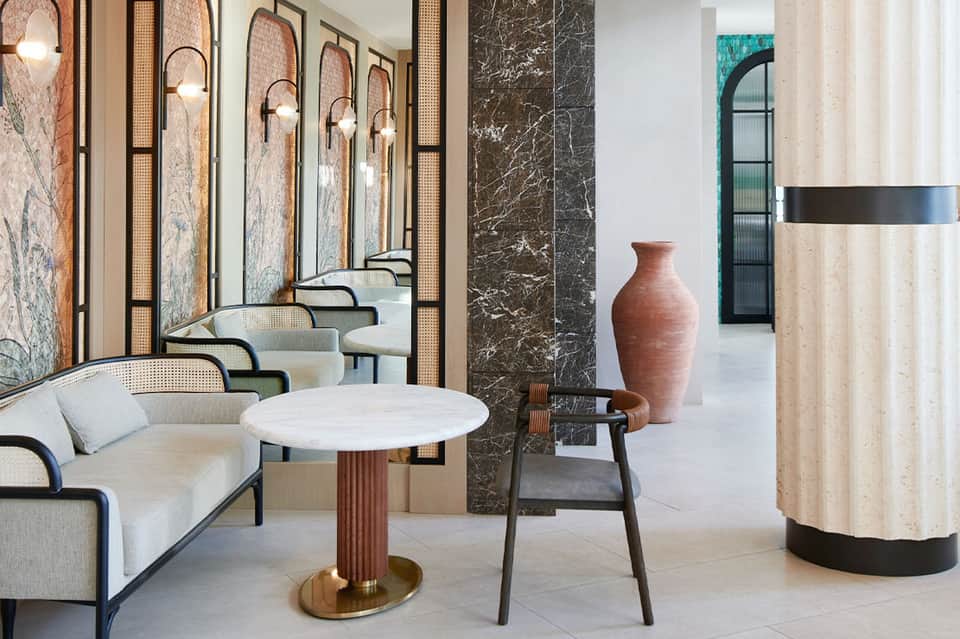 Modern resort lobby with curved seating, marble walls, and contemporary décor