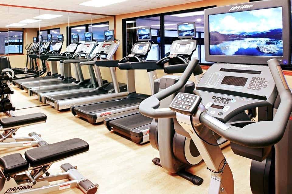 Fitness center with rows of treadmills and exercise equipment