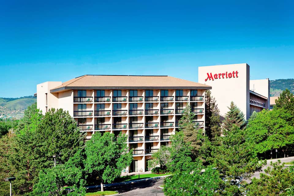 Marriott hotel exterior surrounded by lush green landscaping with mountains in background