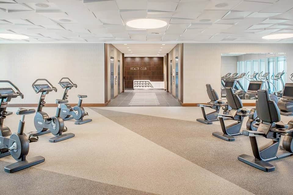 Modern health club with stationary bikes and exercise equipment lined in rows