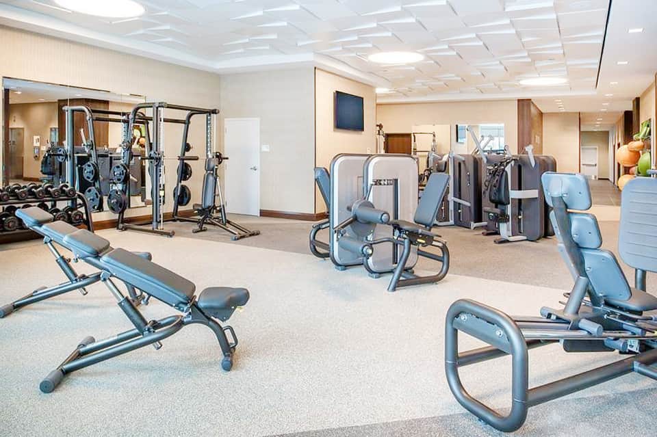 Fitness center with exercise equipment including bikes, weights, and strength machines