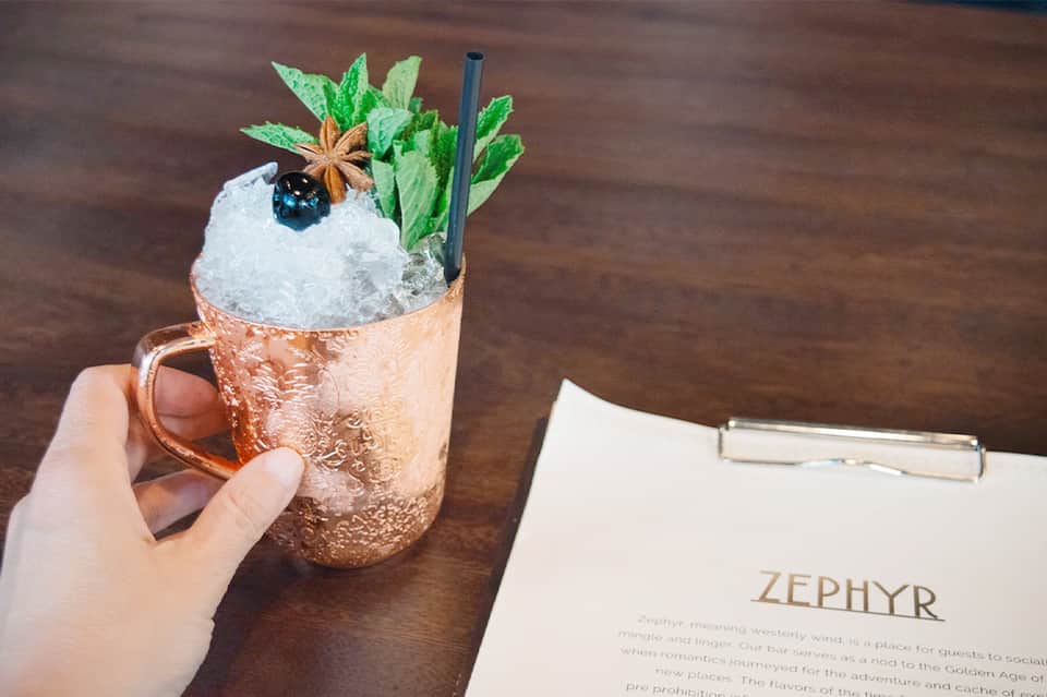 Craft cocktail in copper mug with mint and star anise in upscale bar setting