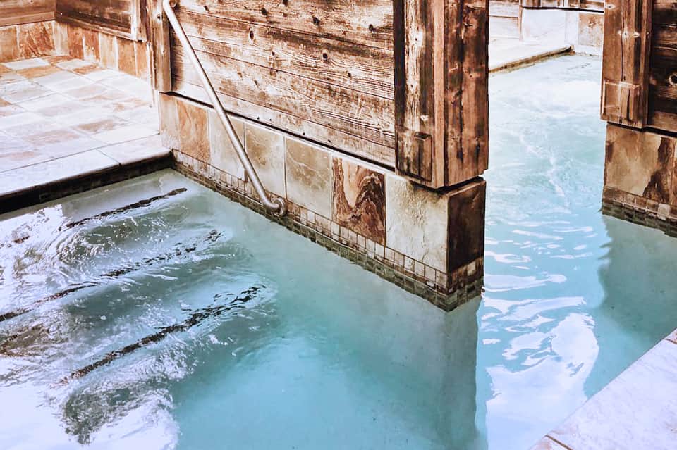 Rustic wooden hot spring bathing pools with turquoise geothermal water
