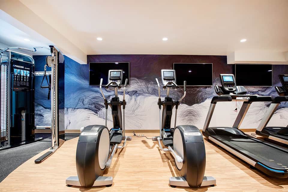 State-of-the-art gym with exercise bikes, artistic wall mural, and cardio equipment