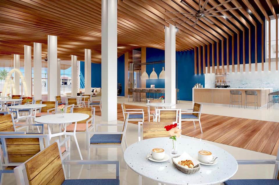 Modern cafe interior with wooden ceiling, white furniture, blue accent wall, and bar seating