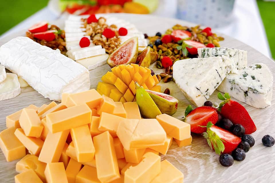 Cheese and charcuterie platter with fresh fruits, nuts, and assorted gourmet selections