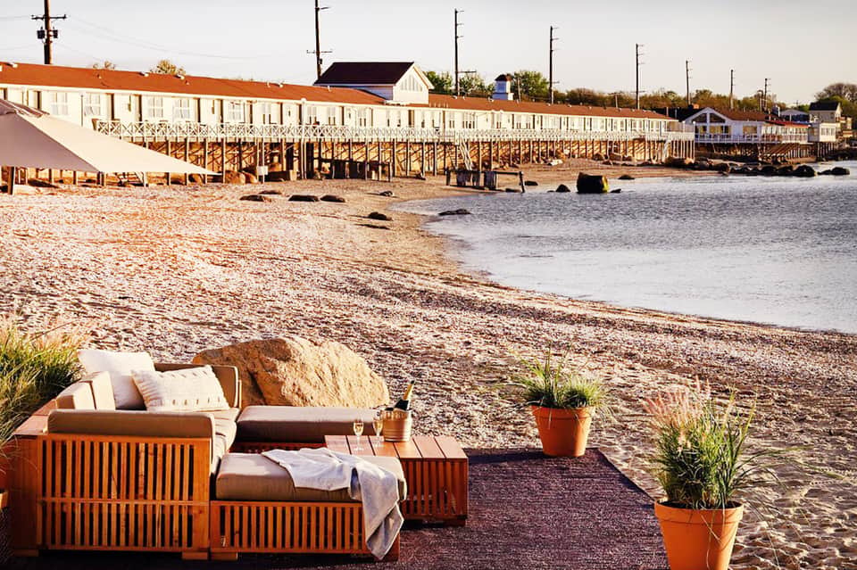 Beachfront lounge area with wooden cabanas and view of historic waterfront buildings