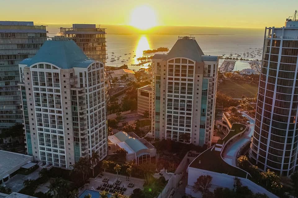 Beachfront resort buildings at sunset with ocean view and warm golden lighting