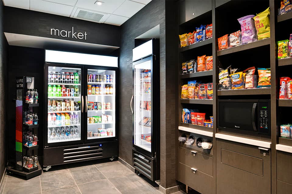 Hotel market snack area with refrigerated beverage coolers and shelves of packaged snacks