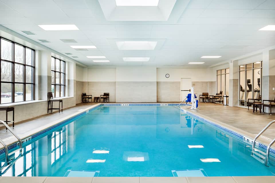 Indoor lap pool with lane markings, natural lighting, and modern facility architecture