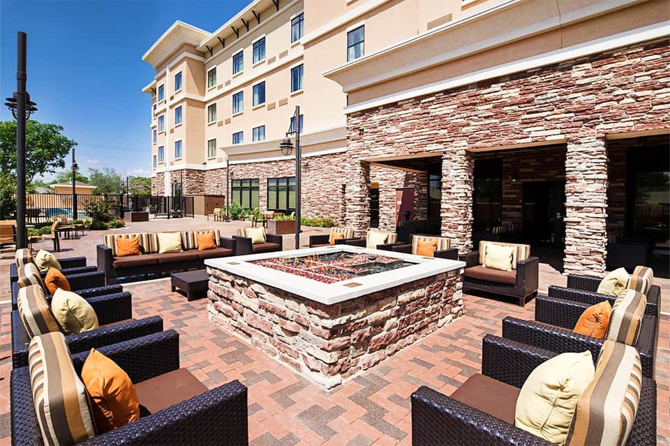Resort patio with fire pit, wicker furniture, and stone accents
