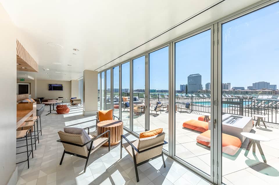 Modern high-rise apartment with floor-to-ceiling windows overlooking waterfront cityscape