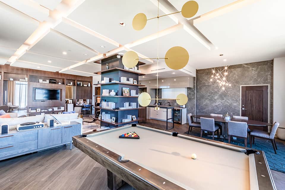 Game room with pool table, blue cabinetry, and brass decorative spheres hanging from ceiling