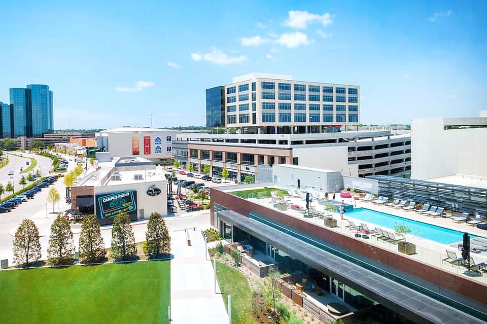 Urban hotel complex with pool deck, modern architecture, and surrounding buildings