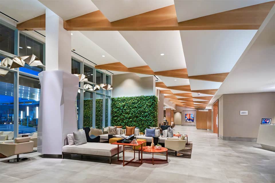 Modern hotel lobby with wooden ceiling beams, living wall, and contemporary furnishings