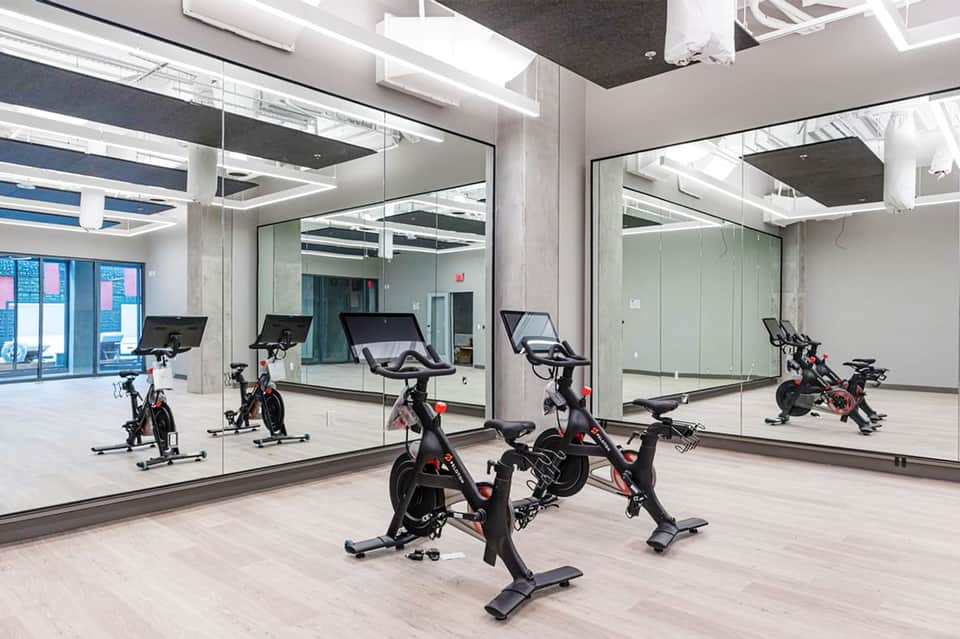 Modern fitness studio with stationary bikes and mirrored walls reflecting exercise equipment