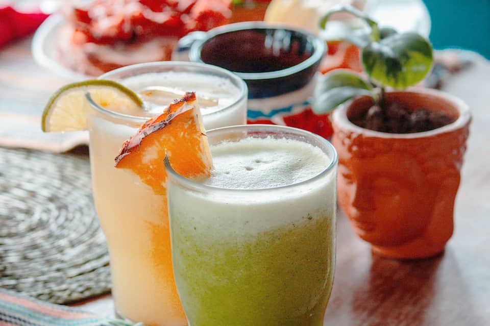 Colorful cocktails with lime and grapefruit garnishes, sauces, and tropical seaside presentation