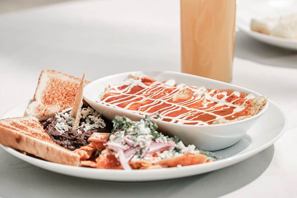 Gourmet seafood platter with crab toast, prawns, and sauce drizzle on white plate