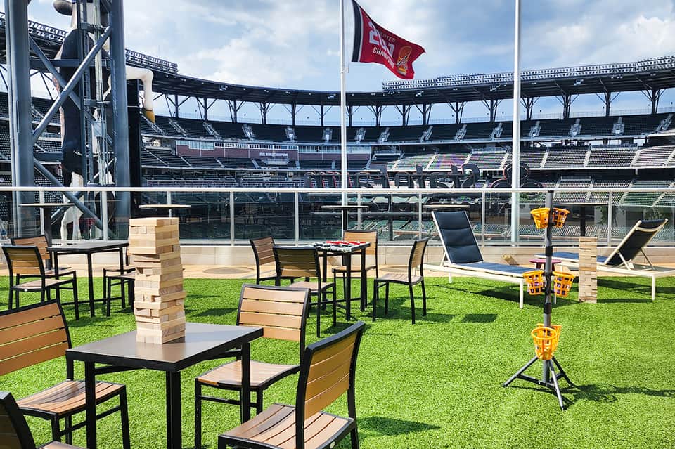 Outdoor lawn games setup at stadium with red flag and seating areas overlooking field