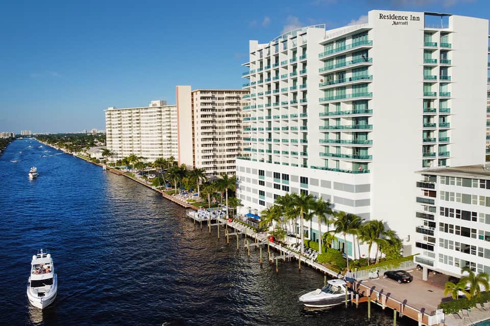 Waterfront Residence Inn Marriott hotel on a scenic canal with palm trees and boats