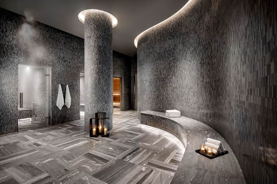 Modern spa area with rainfall columns, mosaic tile walls, and ambient lighting