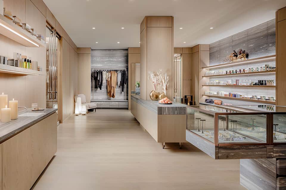 Luxury spa interior with wood cabinetry, shelving, mirrors, and boutique displays