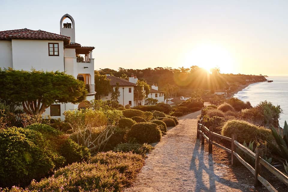 Coastal Spanish-style villas at sunset on hillside overlooking ocean