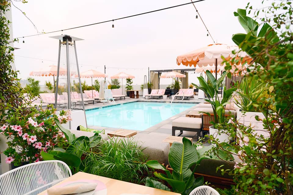Poolside dining area with umbrellas, lounge chairs, and string lighting