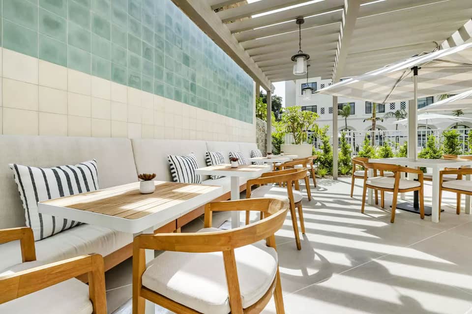 Modern resort dining area with striped pillows and pergola shade