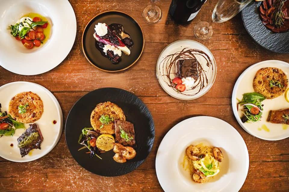 Fine dining table with multiple gourmet plates featuring seafood and creative plating