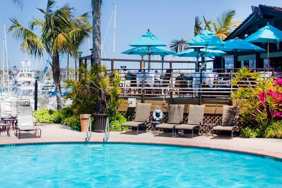 Waterfront pool with turquoise umbrellas and marina views