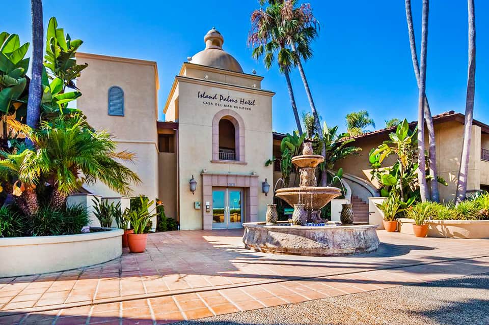 Island Palms Hotel entrance featuring Spanish colonial architecture with fountain and palm trees