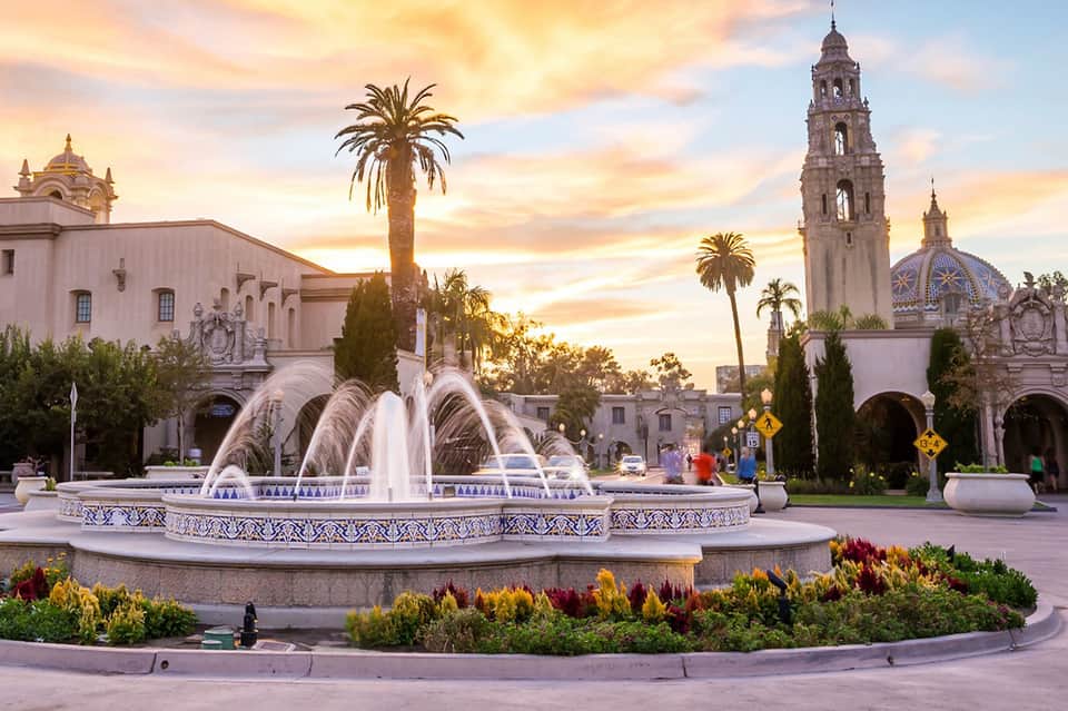 Ornate fountain at sunset in front of Spanish colonial architecture and bell tower