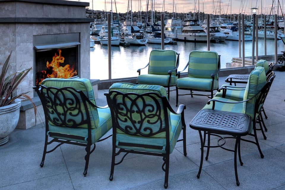 Waterfront lounge seating with fireplace overlooking a marina at dusk