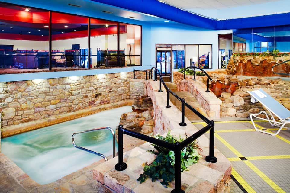 Indoor hot spring spa with stone walls and heated pools